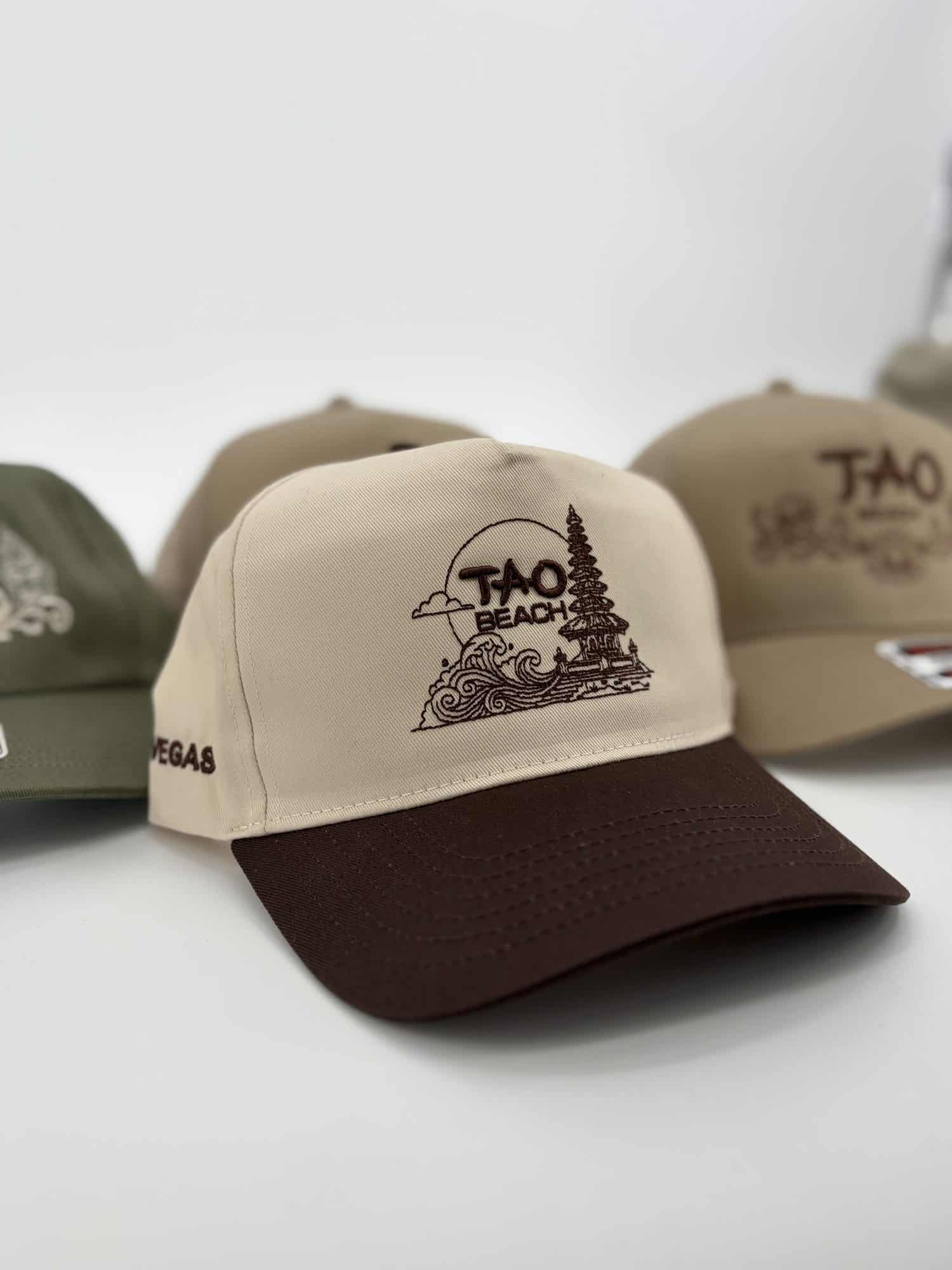 Cream and brown two-tone caps with detailed brown embroidery on the front and "Vegas" stitched on the side, made at Alive Print Shop.